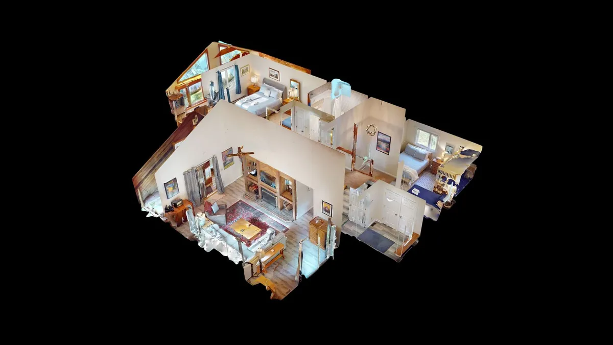 A spacious and warmly lit living area with cozy furniture, well-lit bedrooms in the background, and decorative artwork accentuating the walls. The open layout fosters a sense of togetherness and relaxation for group gatherings or quiet evenings in.